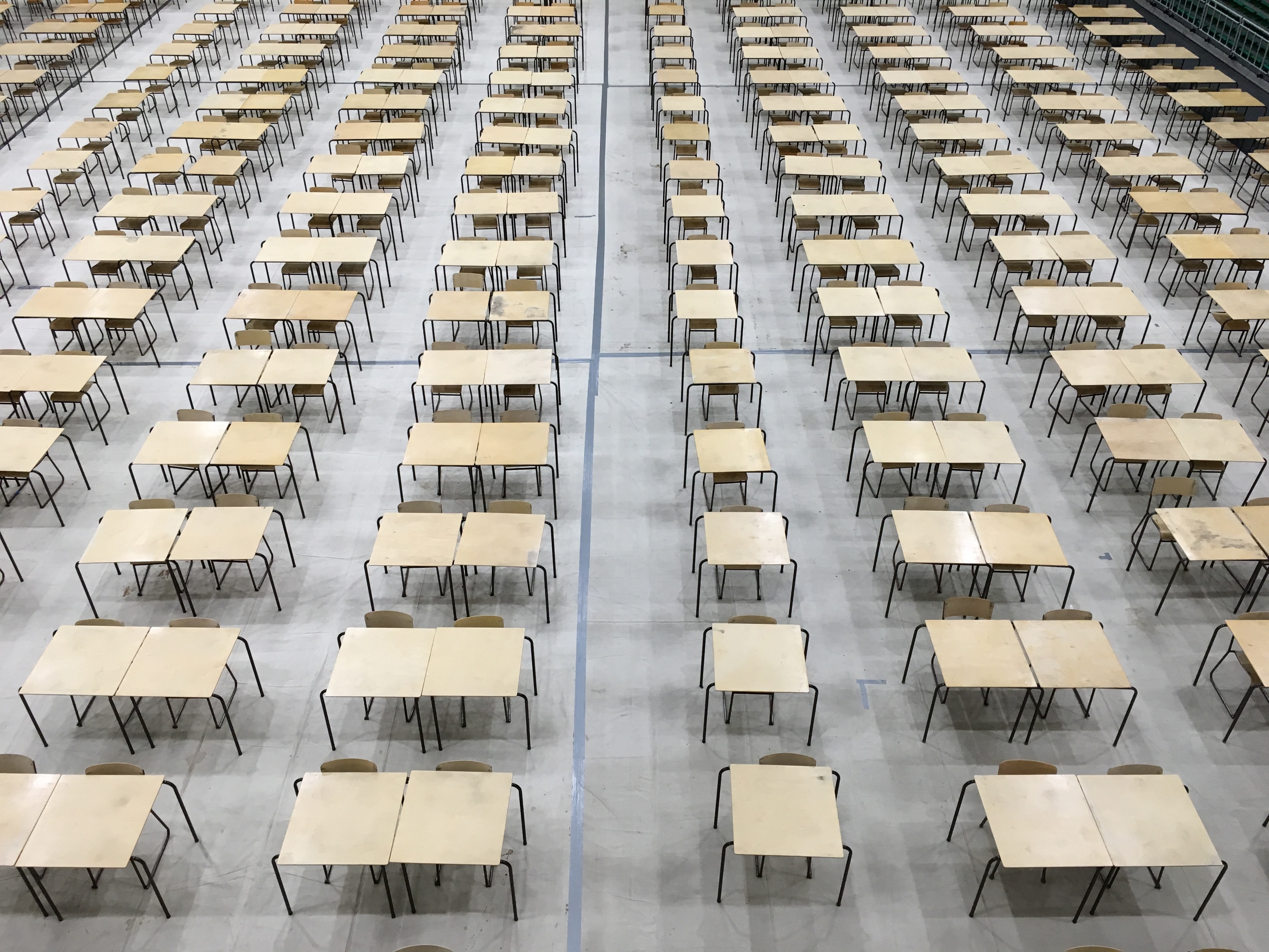 An empty row of desks set up for taking a test.